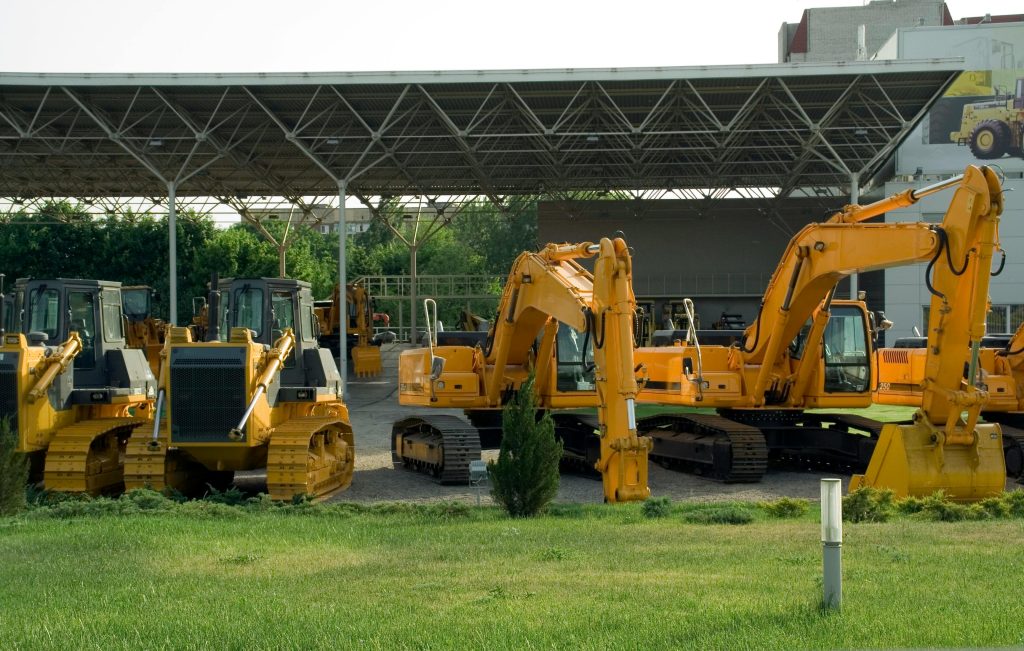 Heavy-duty construction machinery displayed outdoors, include excavators and bulldozers.